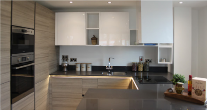 Kitchen interior of an apartment with an oven, sink, hobs, worktop and cupboards